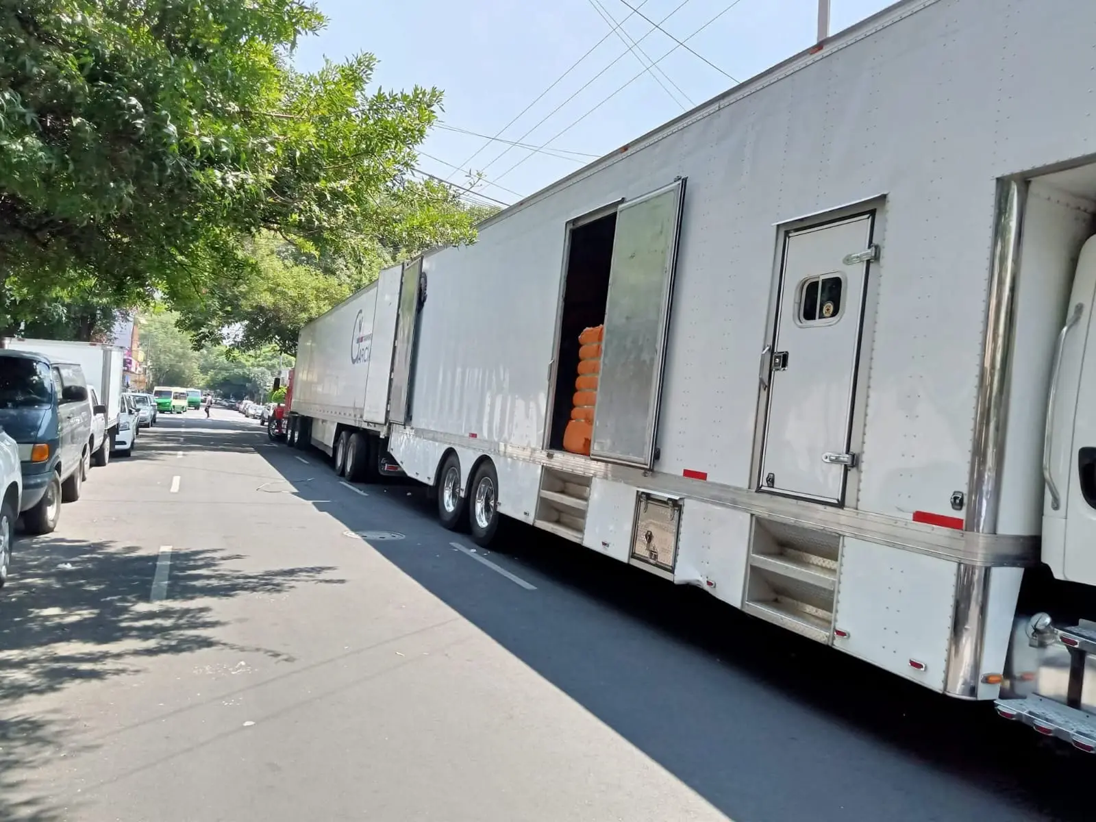 Gran camión de mudanzas blanco de caja cerrada estacionado en la calle con accesos abiertos para servicio compartido